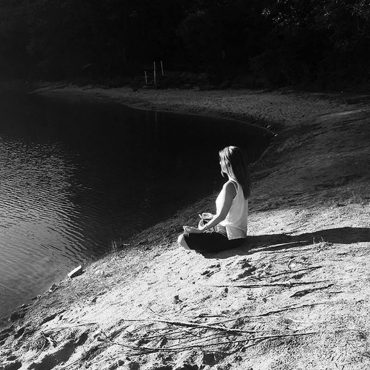 Natasha Moine meditating on beach